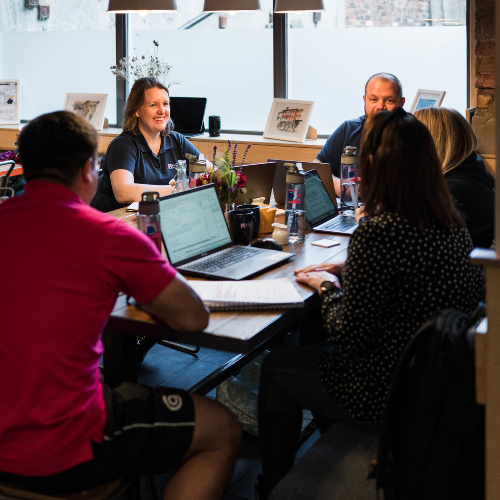 The Kan Do Ventures team all sat around a table discussing a project